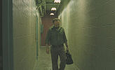 Cleveland Heep (Paul Giamatti) walking down a hallway.
