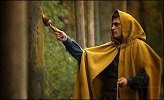 Joaquin Phoenix painting trees on the edge of the surrounding forest in 